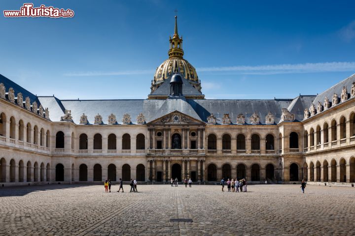 Immagine Il cortile d'onore dell'Hotel des Invalides, Parigi (Francia) - La fotografia mostra uno spazio così ampio da ricordare una cartolina di Venezia appartenente agli anni del vedutismo, ma in realtà si tratta dello spazio ampio che abbraccia la parte esterna dell'Hotel des Invalides a Parigi. Qui la cornice architettonica riesce a essere discreta e, nonostante le sue notevoli dimensioni che rivelano sullo sfondo la preziosa cupola dorata, fatta erigere come spazio privato di Luigi XIV e che attualmente racchiude la tomba di Napoleone, nel complesso il risultato appare armonioso e in sintonia con l'ambiente circostante - © anshar / Shutterstock.com