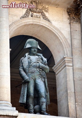 Immagine La Statua di Napoleone custodita all'Hotel des Invalides, Parigi (Francia) - Custodita, sì, perché la scultura marmorea raffigurante il condottiero militare più famoso di tutta la nazione francese non è maestosa, imponente e non è neanche di dimensioni monumentali ma al contrario, con il suo materiale forgiato da bronzo appartenente alle armi nemiche, giace in tutta la sua discrezione e sagacia sotto un prezioso arco. Scelta stilistica che risale al 1833 e che in realtà nasconde un importante insegnamento: quando una personalità ha dentro personalità (gioco di parole che piacerebbe a Charles Emile Marie Seurre, l'autore della statua), non ha bisogno di presentazioni trionfali - © KKulikov / Shutterstock.com
