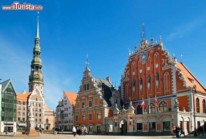 Immagine Il centro storico patrimonio UNESCO di Riga: in evidenza la casa delle  teste nere e campanile della chiesa di San Pietro - © strelka / Shutterstock.com