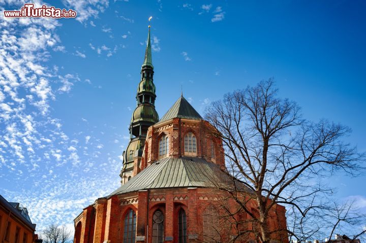 Immagine La bella chiesa luterana, costruita in mattoni, di San Pietro si trova nel centro patrimonio UNESCO di Riga. La vediamo fotografata in una splendida giornata di sole della Lettonia - © Konstantin Tronin / Shutterstock.com