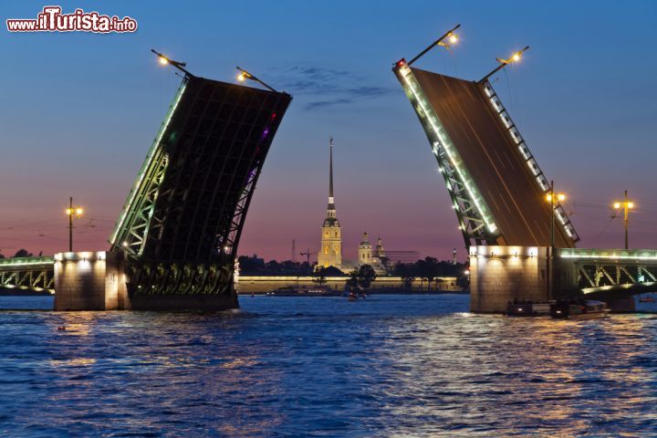 Immagine Una fotografia classica delle notti bianche di San Pietroburgo: sulle spettacolari rive del fiume Neva con un ponte mobile aperto e, sullo sfondo, la Fortezza di Pietro e Paolo, una delle icone della Russia zarista - © Anton Balazh / Shutterstock.com