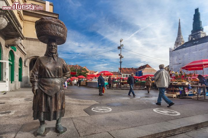 Immagine Il simbolo del Dolac di Zagabria è la statua dedicata alla Kumica, la tipica massaia della Croazia, la vera protagonista del più grande mercato ortofrutticolo della nazione. L'artista che ha immortalato la Kumica tipica è Stjepan Gracan - © Ivica Drusany / Shutterstock.com