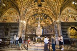 Dentro al Battistero di Siena: in posizione centrale troviamo l'elegante fonte batttesimale, notevole opera d'arte del primo Rinascimento Italiano, che tra gli autori annovera lo stesso ...