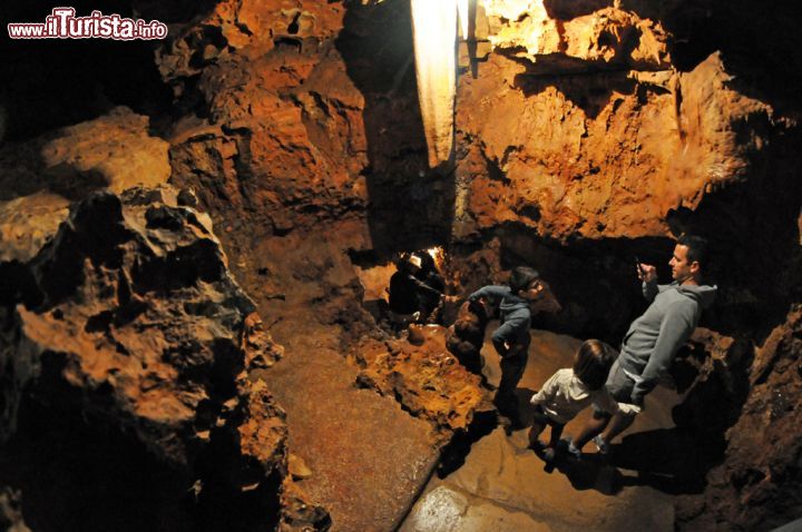 Immagine Sono delle strette scalinate ad accompagnare i visitatori in questo percorso nel sottosuolo della grotta di Saint-Cezaire-sur-Siagne dove si possono ammirare formazioni calcaree dai colori più bizzarri. Il caratteristico colore arancione della roccia è dovuto alla presenza di ossido di ferro mentre l'umidità dell'ambiente, l'argilla e soprattutto la luce portano alla formazione del muschio che si trova poco più in alto - © Sonja Vietto Ramus