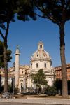 Una prospettiva originale della Colonna Traiana, fotografata tra i pini di via dei Fori Imperiali. A destra la Chiesa Cattolica SS. Nome di Maria - © sokolovsky / Shutterstock.com