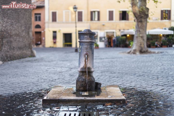 Immagine Una fontanella del rione Trastevere a Roma. Le fontane di Roma sono dotate di un foro sulla parte superiore della cannella che fa uscire l'acqua, e quindi basata tappare con un dito la cannella per poter bere comodamente lo zampillo che fuorisce dall'apertura. L'acquedotto che serve tratevere è quello dell'Acqua Paola - © saaton / Shutterstock.com