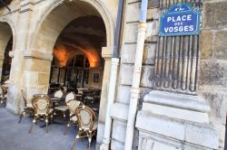 Un Caffè tipico di Parigi sotto i portici di Place des Vosges in Francia - © Rrrainbow / Shutterstock.com