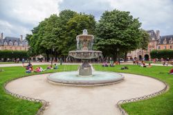 Scorcio di una fontana a Place des Vosges a Parigi. I francesi si rilassano molto volentieri in questa piazza, nelle calde giornate di primavera ed in estate - © Christian Mueller / Shutterstock.com ...