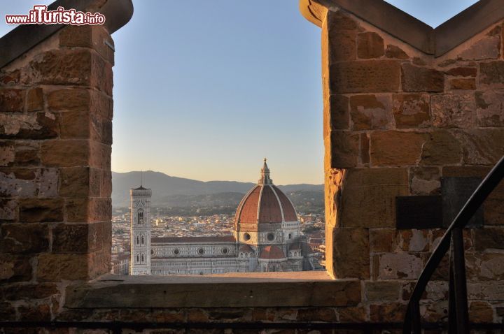 Immagine Il magnifico panorama che si gode dalla cima della Torre di Arnolfo, la struttura alta 94 metri che corona il Palazzo Vecchio di Firenze. Tra i due merli la suggestiva Basilica di Santa Maria in Fiore con la Cupola del Brunelleschi e il Campanile di Giotto - © Claudiovidri / Shutterstock.com