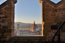 Il magnifico panorama che si gode dalla cima della Torre di Arnolfo, la struttura alta 94 metri che corona il Palazzo Vecchio di Firenze. Tra i due merli la suggestiva Basilica di ...