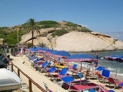 Il promontorio della Tartaruga, tra rocce granitiche e macchia mediterranea, e gli ombrelloni della spiaggia dell'Arenella, Isola del Giglio