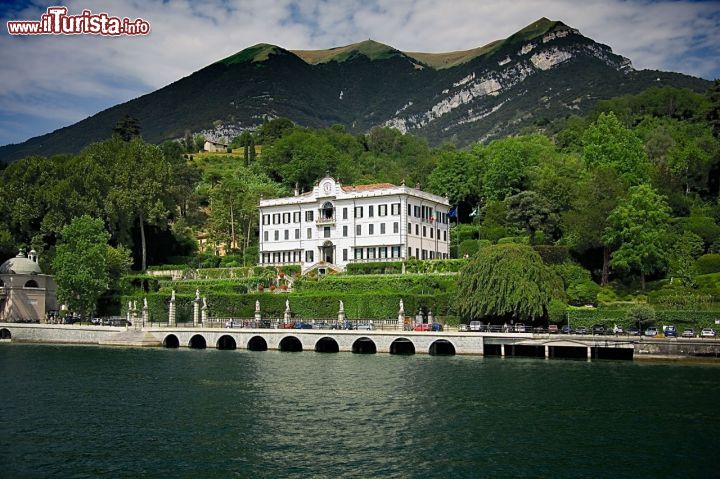 Immagine L'elegante facciata di Villa Carlotta fotografata da una barca emerge tra la rigogliosa vegetazione sulla riva del lago di Como - foto © www.villacarlotta.it
