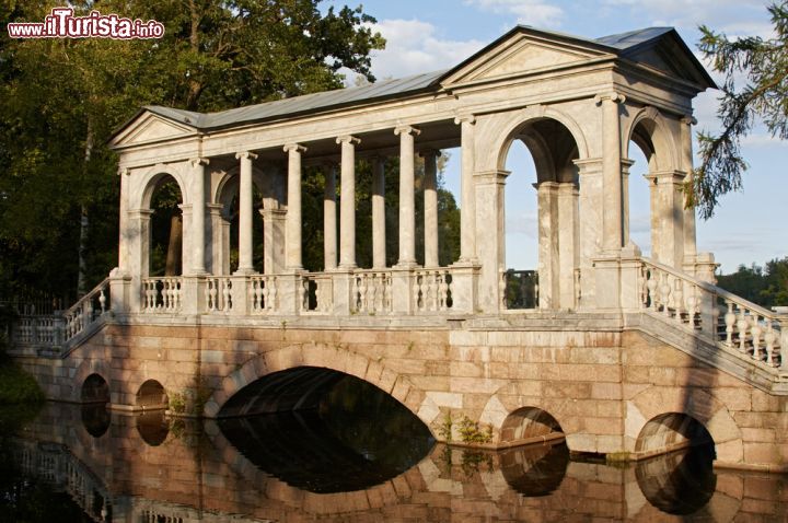 Immagine Un ponte nel parco di Caterina a Pushkin, Russia. Si riflette nell'acqua questo ponte coperto fatto costruire dall'imperatrice di Russia per adornare il vasto giardino che circonda la residenza - © Maksim Budnikov / Shutterstock.com