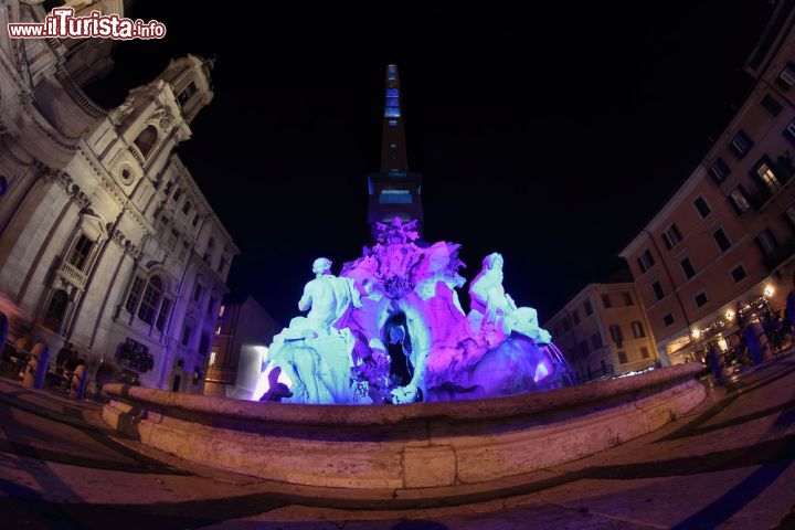 Immagine Notte di Natale a Piazza Navona con la fontana dei Quattro Fiumi illuminata, Roma. Nel periodo natalizio la piazza si illumina di mille colori e si riempie di bancarelle di dolci, oggetti di artigianato locale e statuine per il presepe - © marcovarro / Shutterstock.com