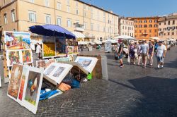 Panorama di Piazza Navona con bancarelle di dipinti e turisti, Roma, Italia. La maestosa piazza centrale di Roma ritratta in un'estiva giornata di sole con i turisti a passeggio e le bancarelle ...