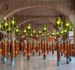 La sala delle sculture romaniche presso il Musée des Augustins di Tolosa. I capitelli sono appoggiati su colonne colorate e la sala è fresa vivace dai lampadari che pendono dal ...