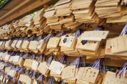 Preghiere su tavolette di legno nel santuario di Meiji Jingu a Tokyo - theendup / Shutterstock.com