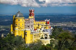 Veduta panoramica del Pena National Palace a Sintra, Portogallo. Guglie smaltate, ponte levatoio, cupole in stile arabo e colori pastello: sembra quasi di essere in un parco divertimenti  ...