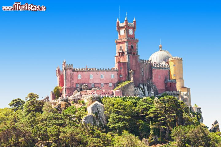 Immagine Una bella immagine del Castelo da Pena a Sintra, Portogallo. Situato sulle colline della città portoghese di Sintra, nei pressi di Lisbona, questo sontuoso palazzo venne fatto costruire negli anni successivi al 1840 da Maria II di Braganza come regalo di nozze per il consorte Ferdinando II di Portogallo. L'architettura di questa costruzione comprende vari stili che vanno dal gotcio al rinascimentale sino al barocco