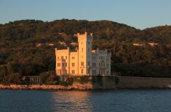Una fotografia dalla barca con il Castello di Miramare al tramonto