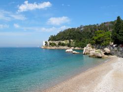 Una spiaggia vicino al Castello di Miramare: il mare limpido del Golfo di Triesteè favorito dalla presenza di rocce calcaree, e l'assenza di fiumi per via dei fenomeni carsici