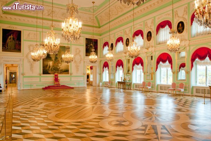 Immagine La Sala del Trono del Gran Palazzo di Peterhof, San Pietroburgo, Russia. Usato dallo zar di Russia, il trono di Peterhof era posizionato lungo il muro orientale del palazzo con dietro un grande dipinto di Caterina II di Russia a cavallo. La sala, fra le più belle del complesso reale, ospita anche dipinti a olio e lampadari sontuosi - ©  Sergey_Bogomyako / Shutterstock.com