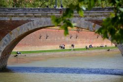 La gente ama passeggiare sulle rive della Garonna nei pressi del Pont Neuf, il principale ponte nel centro della città di Tolosa (Francia)