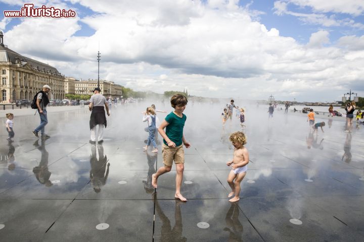 Immagine Bambini giocano tra le fontane dello Specchio d'Acqua di Place de la Bourse a Bordeaux, Francia - © Cloud Mine Amsterdam / Shutterstock.com