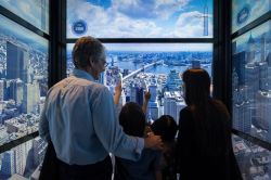 Una famiglia visita the Sky Pods con il panorama del centro di New York CIty