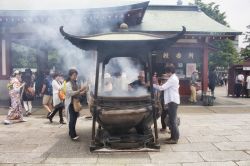 Fedeli in preghiera nel cortile del tempio Senso-ji di Tokyo - © theendup / Shutterstock.com