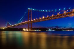 Vista notturna del ponte 25 Aprile, il piu famoso di Lisbona sul fiume Tago. Con una campata unica di oltre 1 chilometro, il ponte è stato al momento della sua creazione il più ...
