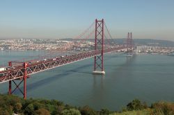 Il ponte sospeso 25 de Abril sul fiume Tago a Lisbona, Portogallo . Chiamato anche come il Golden Gate di Lisbona, è uno dei simboli della capitale del Portogallo. Questa foto è ...