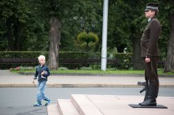 Un bambino osserva una Guardia d'Onore al lavoro presso il Monumento alla Libertà di Riga