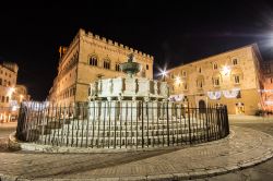 Fotografia notturna di Fontana Maggiore in centro a Perugia e sullo sfondo il Palazzo dei Priori