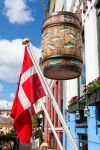 La bandiera danese e un grande barile di legno decorato con pesci a Copenaghen, Danimarca. Le specialità a base di pesce si possono assaporare nei tradizionali ristoranti della città ...