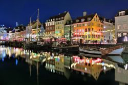 Una veduta serale di Nyhavn a Copenaghen, Danimarca. Su questo bel quartiere affacciato sul lungomare della capitale danese vi sono pittoresche case colorate del XVII° secolo, ristoranti, ...