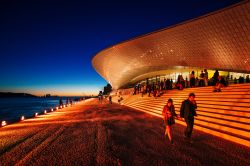 Immagine serale del MAAT di Lisbona, costruito sul lungofiume che costeggia il Tejo su progetto dello studio Amanda Levete Architets © Photography Paulo Coelho, Courtesy EDP Foundation ...