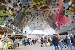 Il soffitto colorato del  Markthal  di Rotterdam. Una volta entrati sotto l'imponente arco, vi troverete sommersi dai colori delle pareti che riportano motivi floreali e frutta ...