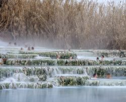 Turisti in relax nelle vasche della Cascata del Mulino a Saturnia