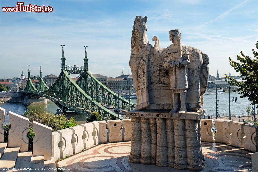 Immagine La statua di Santo Stefano sul monte Gellert, Budapest, Ungheria. Stefano I° è stato il primo re del paese. Sullo sfondo il suggestivo ponte della Libertà, bell'esempio di architettura metallica - © Opachevsky Irina / Shutterstock.com