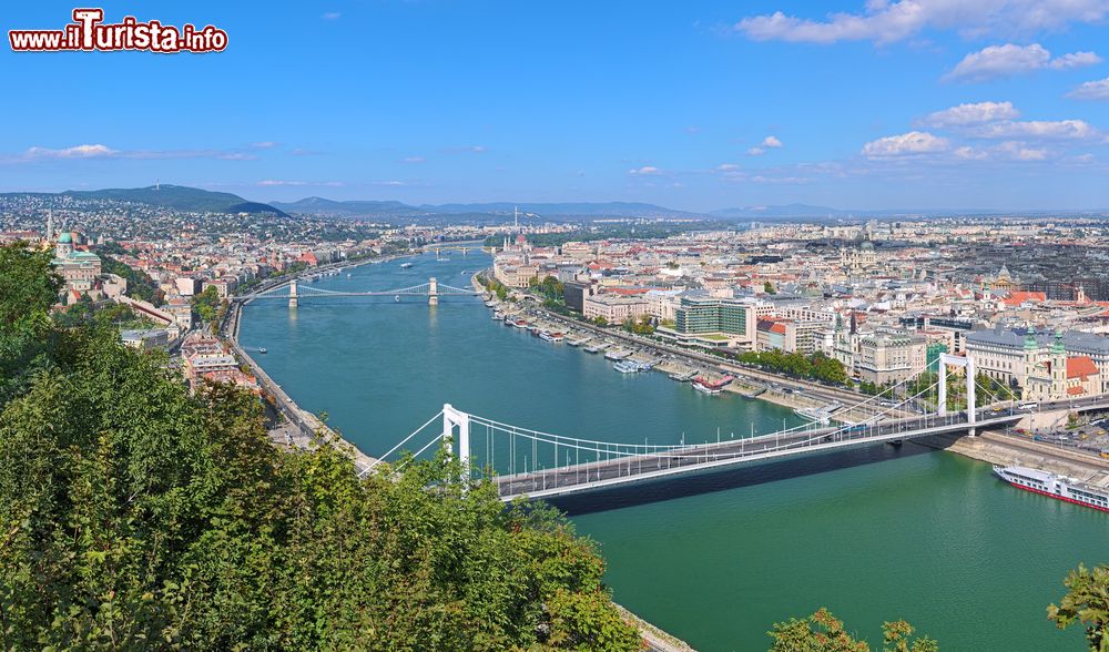 Immagine Una suggestiva immagine della città dalla collina Gellert, Budapest, Ungheria. Lo scorcio panoramico mostra il castello di Buda, il Danubio con i ponti Elisabeth, Szechenyi e Margaret, il Parlamento Ungherese e la basilica di Santo Stefano.