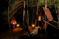Vista nottruna del Tree Village di Claut in Friuli: è possibile pernottare dormendo nelle piccole casette di legno sosbese nel bosco- © www.montagna.es
