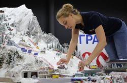 Artista dispone i modellini al Gulliver's Gate di New York. PIù di 10.000 auto e 1000 treni compongono il plastico più grande del mondo - Foto © gulliversgate.com