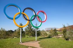 Il simbolo dei giochi olimpici e, sullo sfondo, il velodromo nel parco Queen Elizabeth a Stratford, Londra, Gran Bretagna - © AC Manley / Shutterstock.com