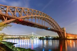 Hell Gate Bridge e, sullo sfondo, il Triborough Bridge di sera. Siamo nel quartiere di Astoria, Queens, New York City.