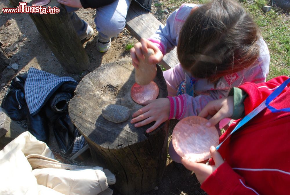 Immagine Attività dei bambini con il mortaio all'Archeopark di Boario Terme in Lombardia