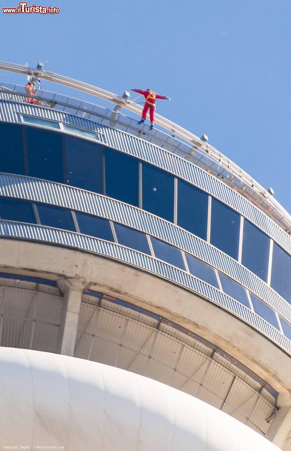 Immagine Un turista affronta la vertigine dell'Edge Walk di Toronto, sul bordo della CN Tower. - © DayOwl / Shutterstock.com