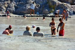 Turisti si godono un momento di benessere tra i fangi delle Terme Libere di Vulcano in Sicilia - © maudanros / Shutterstock.com
