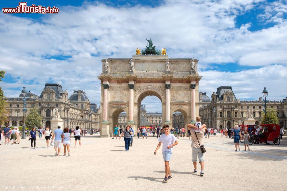 Immagine Giardino delle Tuileries, Parigi: gente a passeggio in una giornate estiva con il Louvre sullo sfondo  - © Kamira / Shutterstock.com