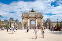 Giardino delle Tuileries, Parigi: gente a passeggio in una giornate estiva con il Louvre sullo sfondo  - © Kamira / Shutterstock.com